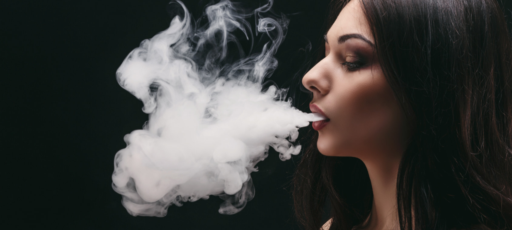 Woman smoking nicotine in a dark room