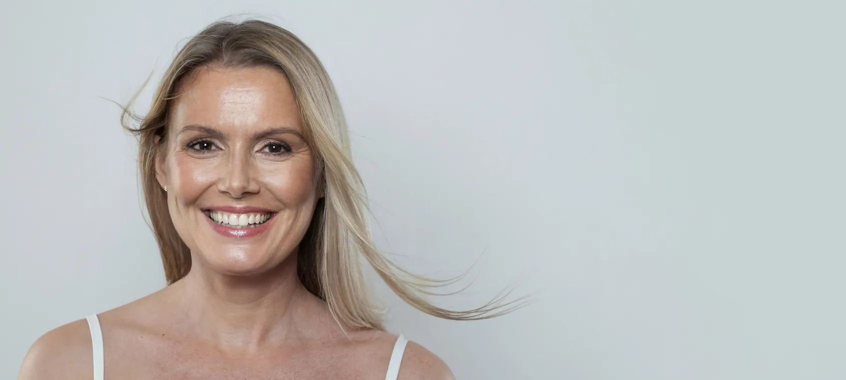 middle aged woman with beautiful skin smiling towards camera